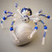 Artisan-crafted blue beaded spider with shimmering silver tones, pearl-like beads, and detailed wirework.